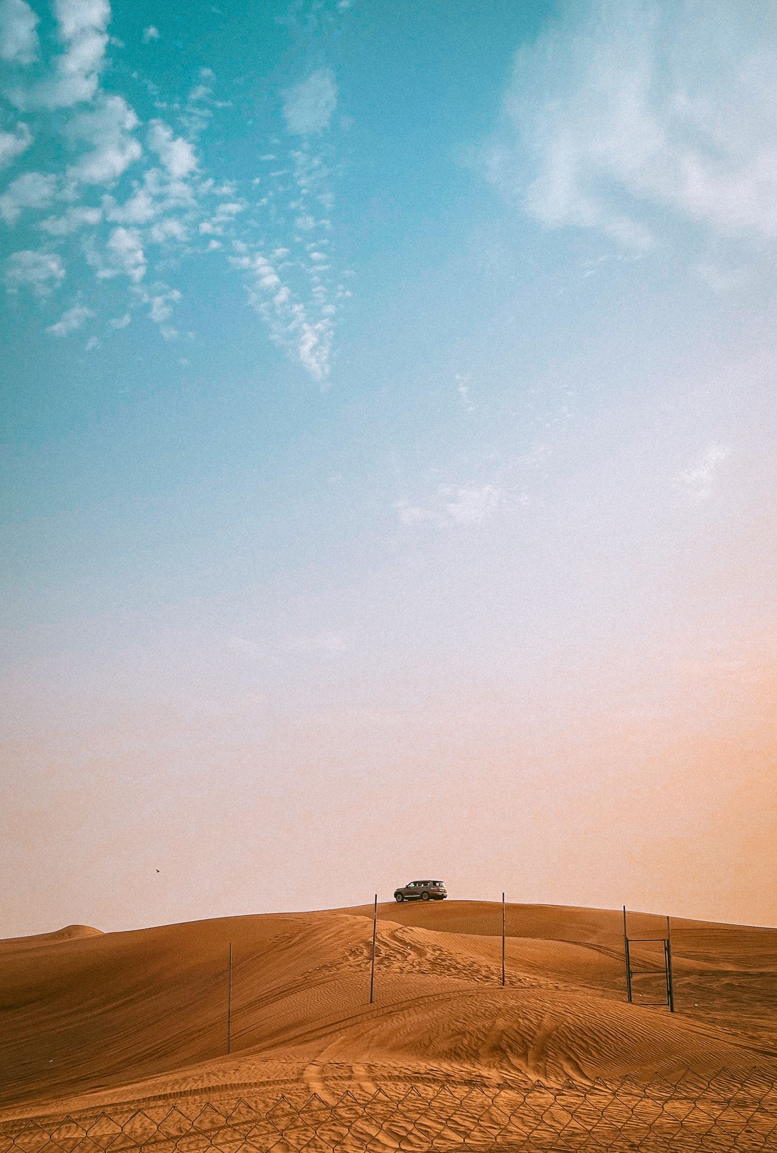 Desert safari vehicle in the dunes outside Dubai at sunset