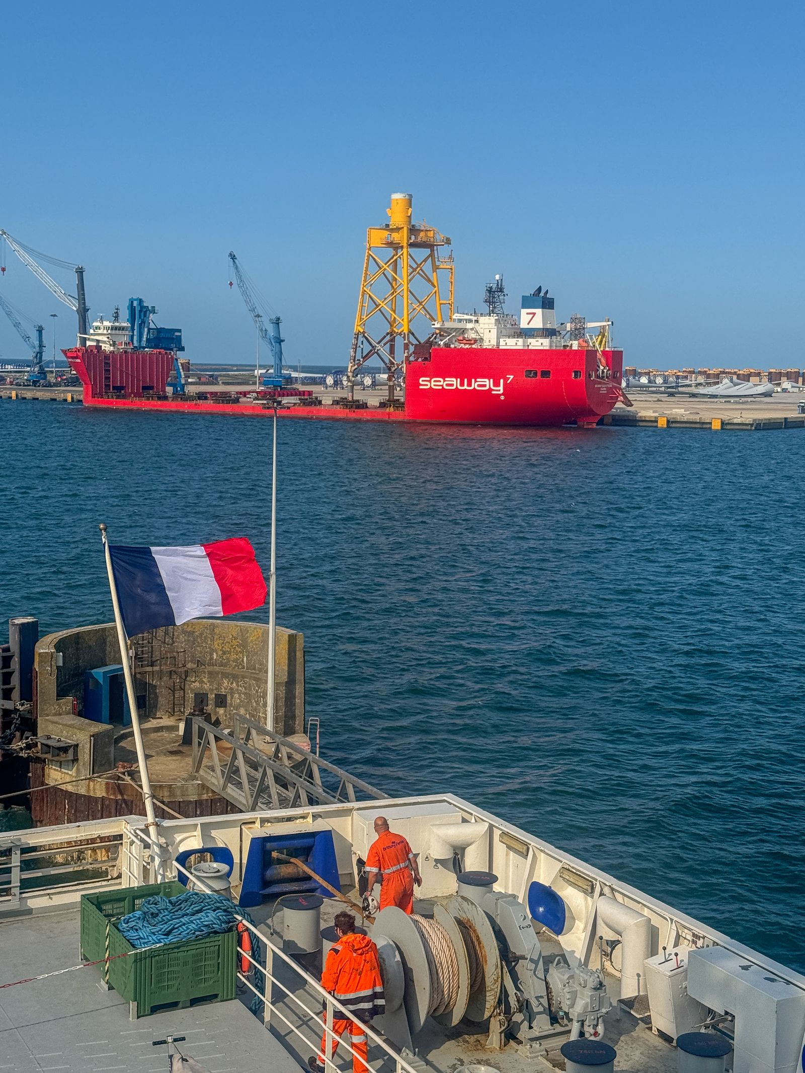 Industrial port scene with a docked vessel and dockworkers