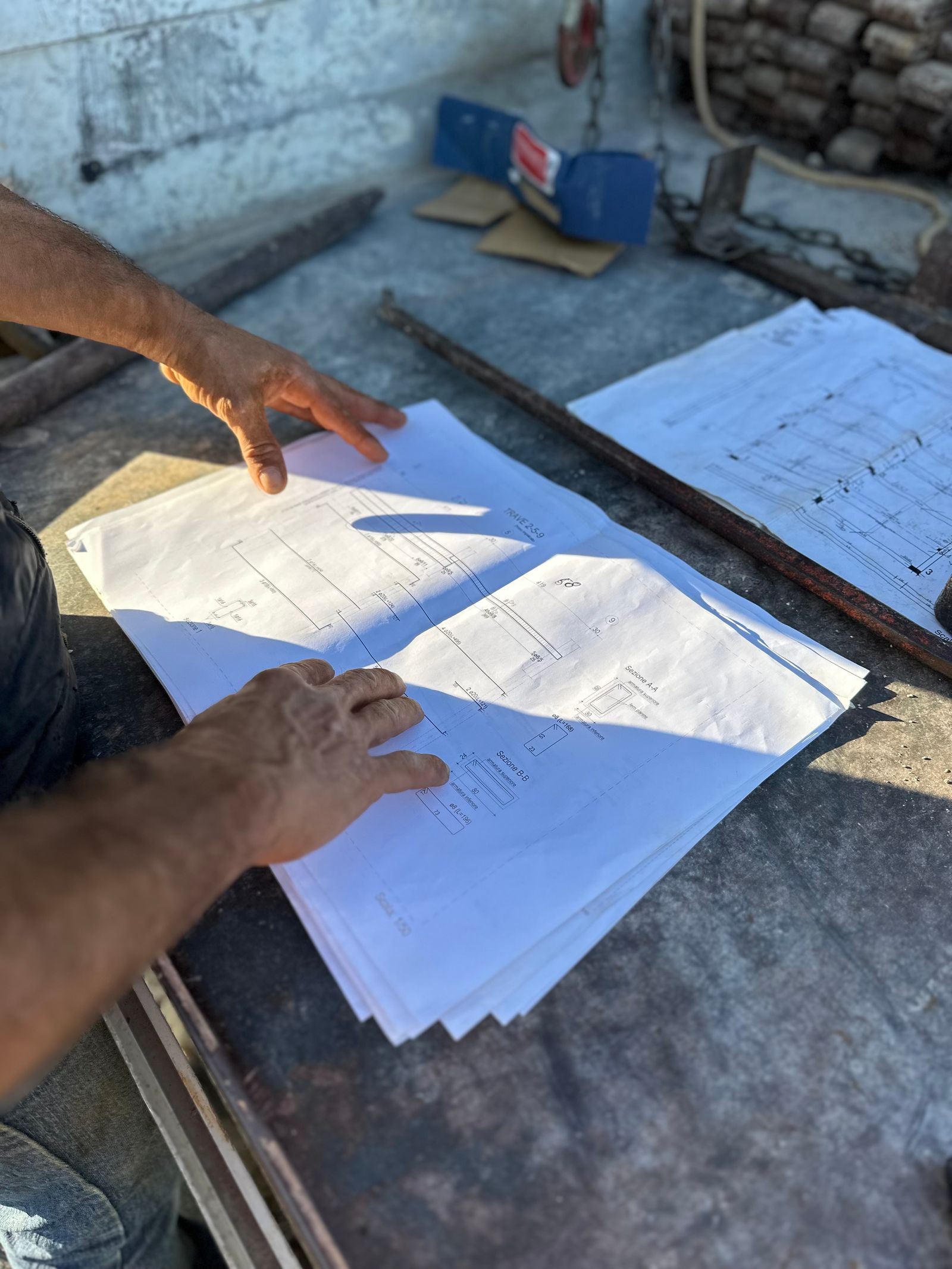 Two engineers reviewing architectural blueprints on site
